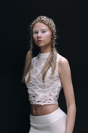 A sleeveless crop top made from soft merino wool. The top part is knitted, and the bottom is felted on using a wet felting technique. The high neckline keeps it simple and easy to wear. ...
